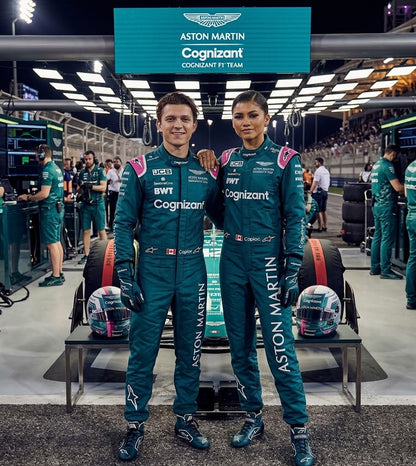Man and woman in teal Aston Martin Cognizant-style racing suits in the pits