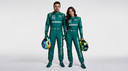 Man and woman in green Aston Martin-style racing suits holding helmets, studio photo