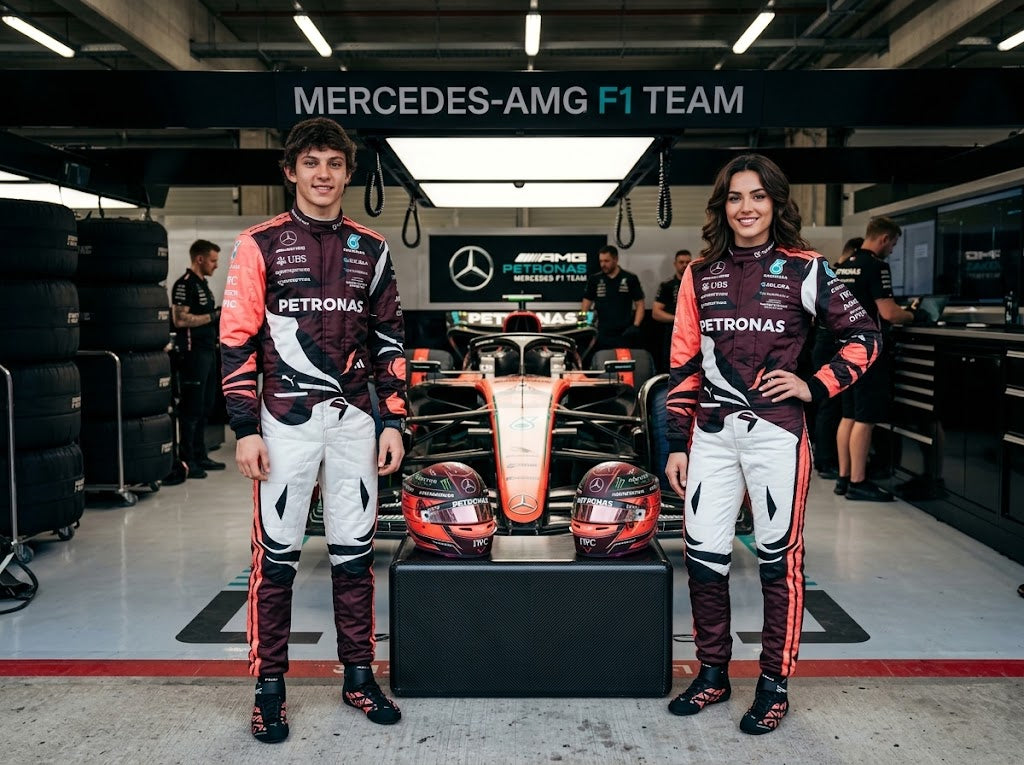 Man and woman in white and maroon Mercedes-style racing suits in front of an F1 car