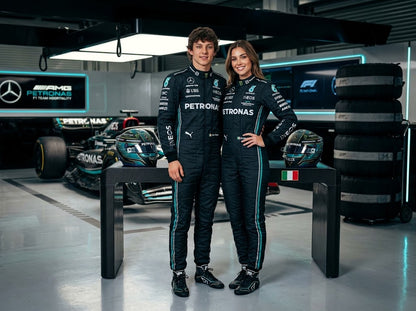 Man and woman in black and teal Mercedes-style racing suits in the garage