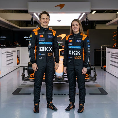 Man and woman in black and blue McLaren racing suits in the garage